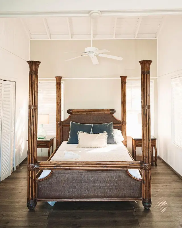 Une chambre lumineuse avec un grand lit à baldaquin en bois.