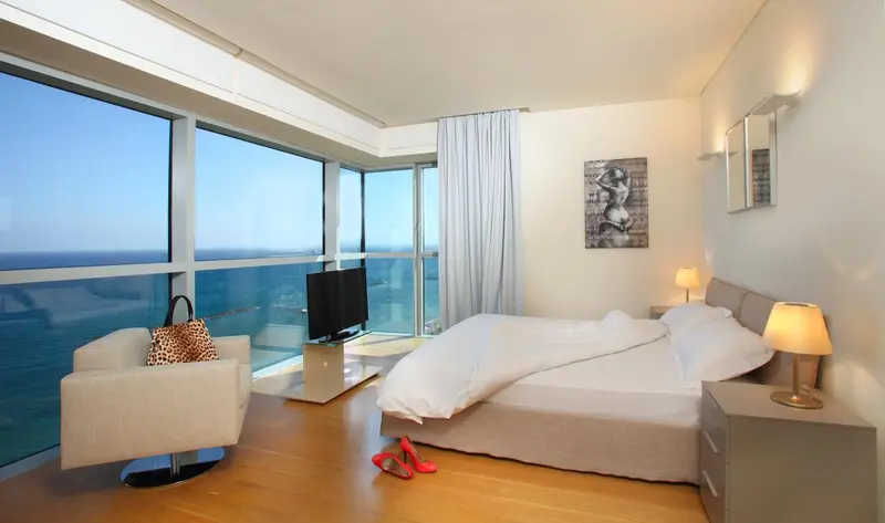 Une chambre lumineuse avec un grand lit et une vue sur la mer.