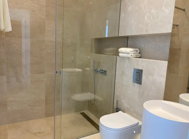 Une douche à l'italienne moderne dans une salle de bain carrelée.