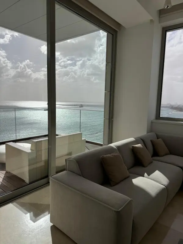 Un salon lumineux s'ouvre sur une terrasse avec vue sur la mer.