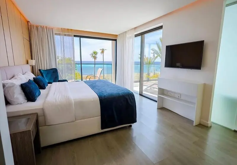 Une chambre lumineuse avec un grand lit et une vue sur la mer.