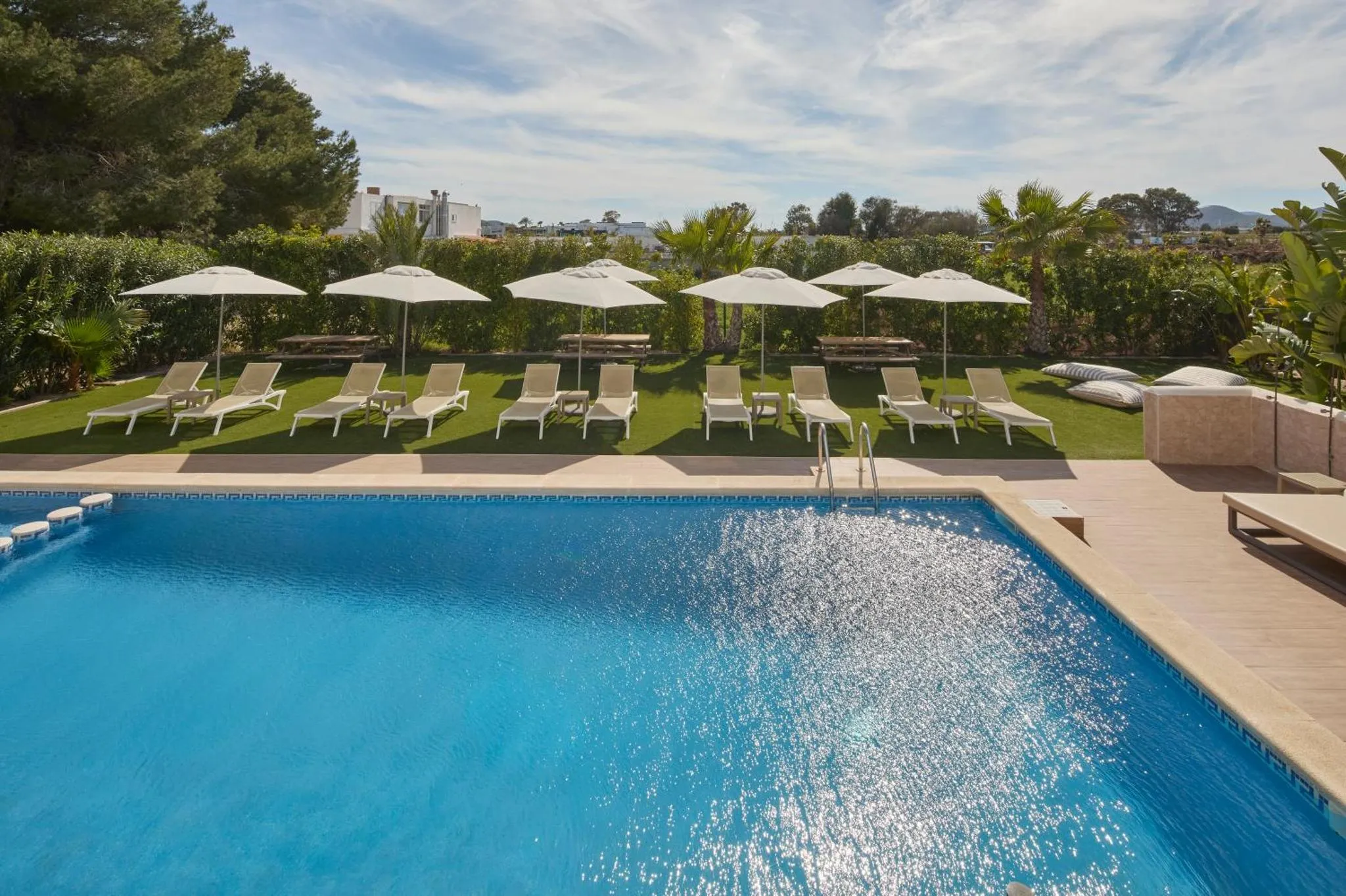 Transats alignés au bord d'une piscine ensoleillée.