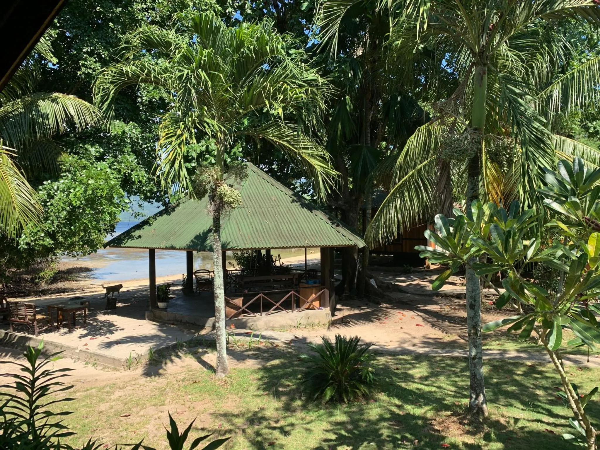 Un abri de plage ombragé offre un espace de détente avec vue sur la mer.