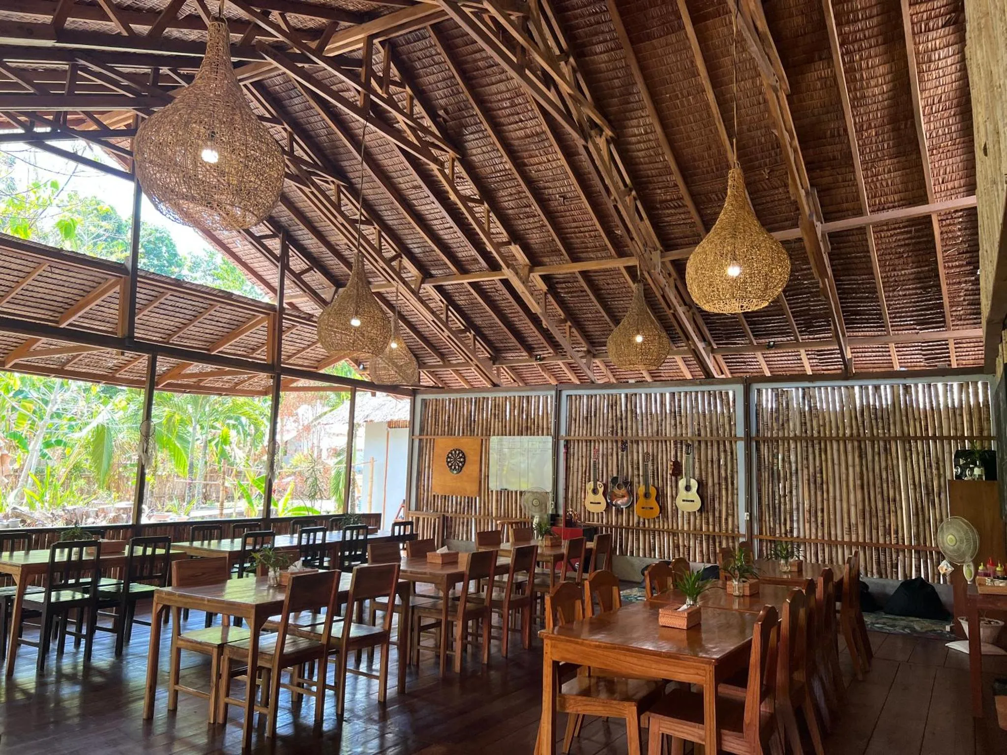 Une salle à manger lumineuse avec de grandes baies vitrées et un plafond en bois.