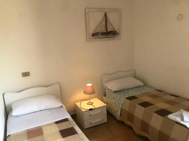 Une chambre lumineuse avec deux lits simples et une décoration murale.