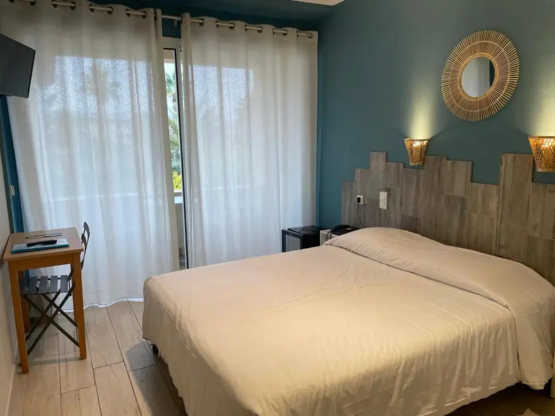 Une chambre lumineuse avec un grand lit et un décor mural en bois.