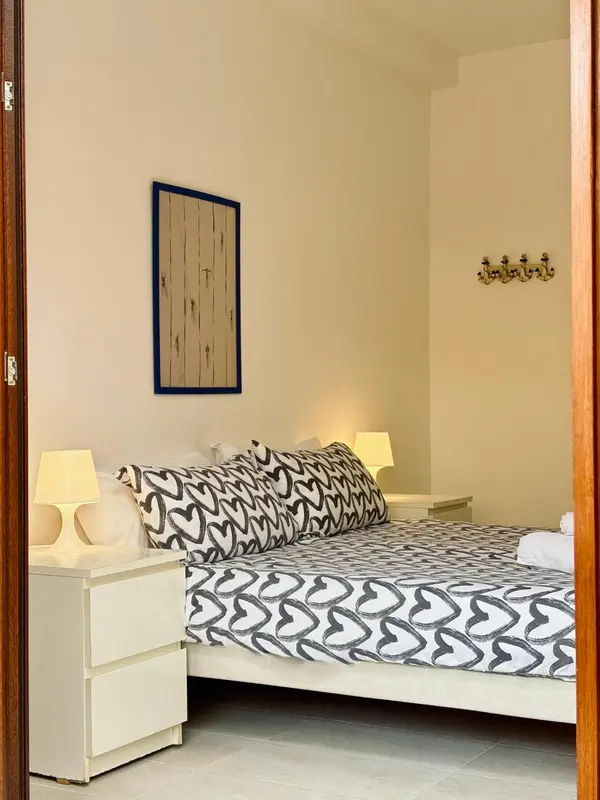Une chambre lumineuse avec un lit recouvert d'une couette à motifs.