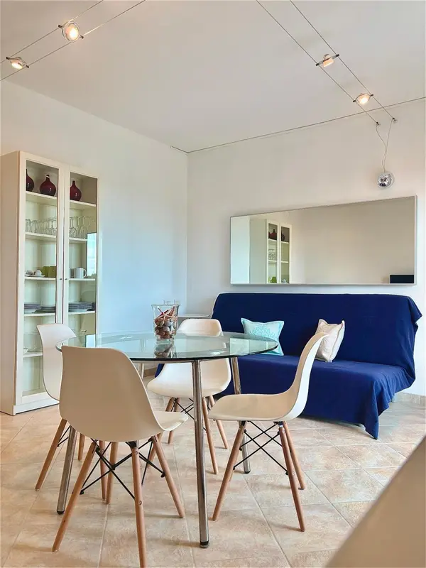 Une salle à manger lumineuse avec une table ronde et des chaises design.