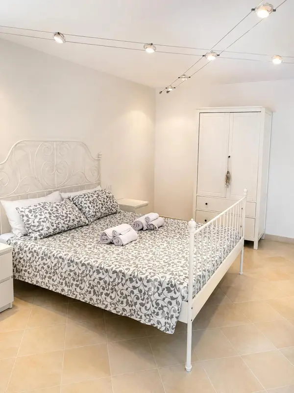 Une chambre lumineuse avec un lit à baldaquin et une armoire blanche.