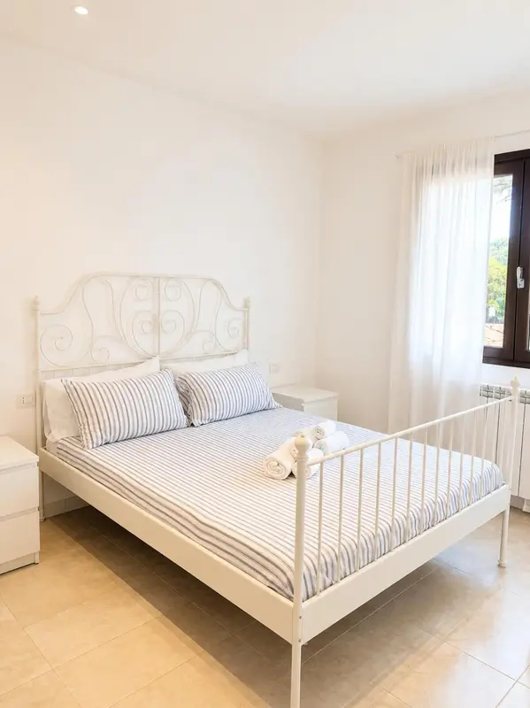 Une chambre lumineuse avec un lit à baldaquin et une décoration sobre.