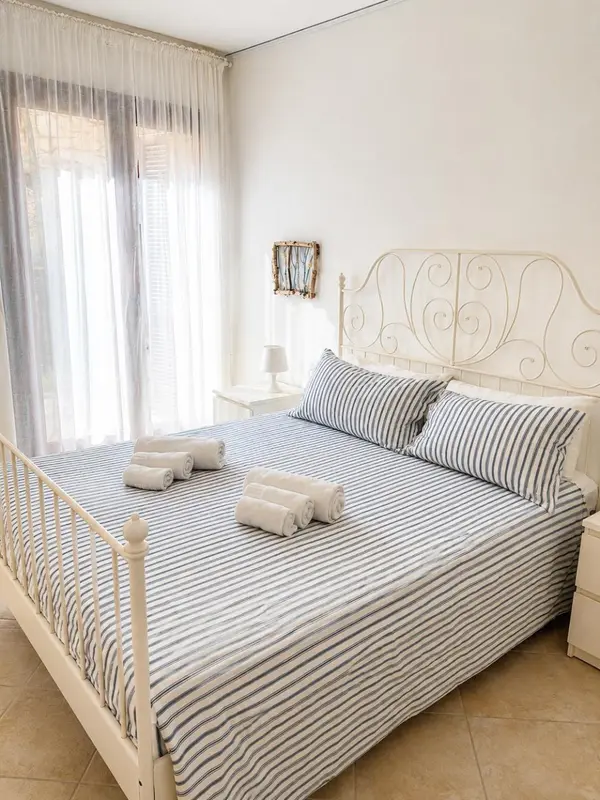 Une chambre lumineuse avec un lit double et des oreillers décorés.