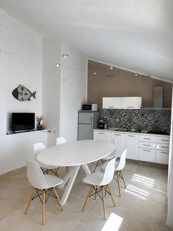 Une salle à manger lumineuse avec une cuisine ouverte.