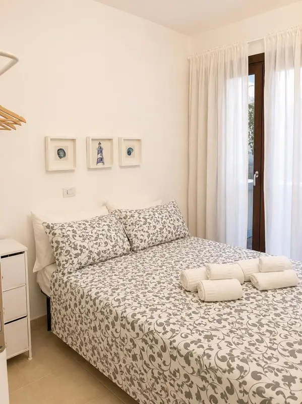 Une chambre lumineuse avec un lit double et des oreillers décorés.