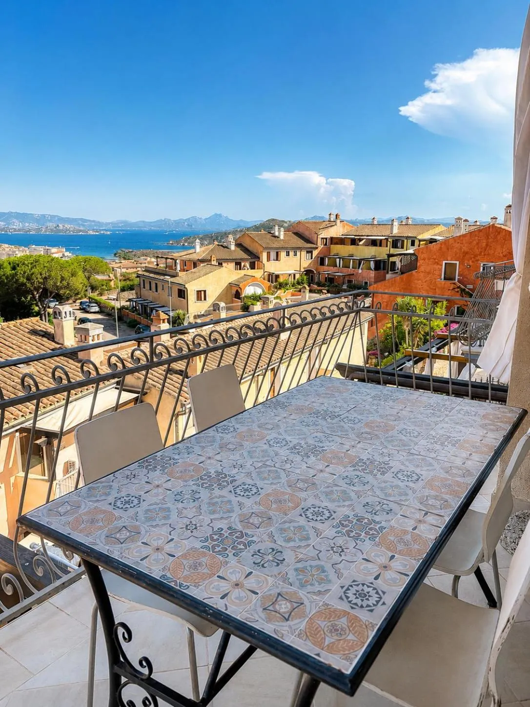 Une table et des chaises sur une terrasse avec vue sur la mer et la ville.