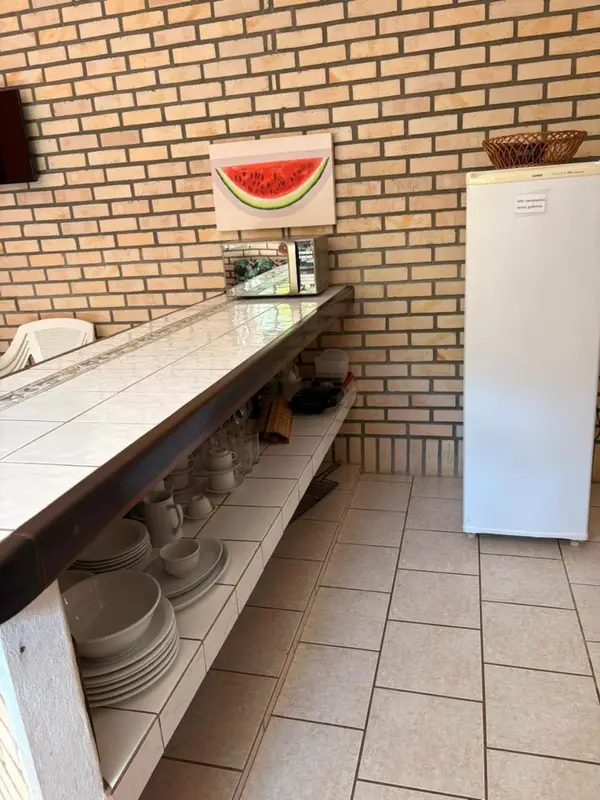 Une cuisine lumineuse avec un comptoir et des étagères remplies de vaisselle.