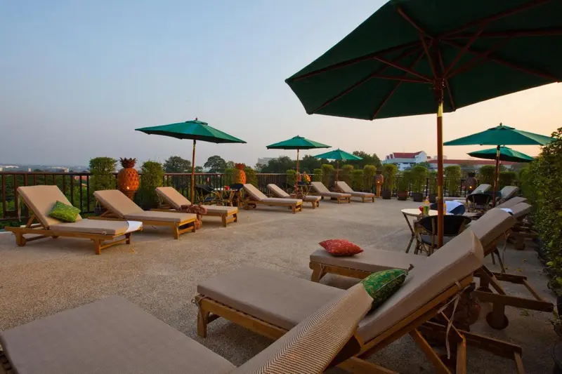 Terrasse aménagée avec des transats et des parasols face à un paysage urbain.