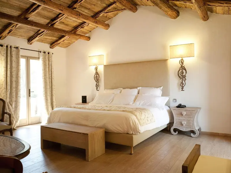Une chambre lumineuse avec un grand lit et des rideaux beiges.