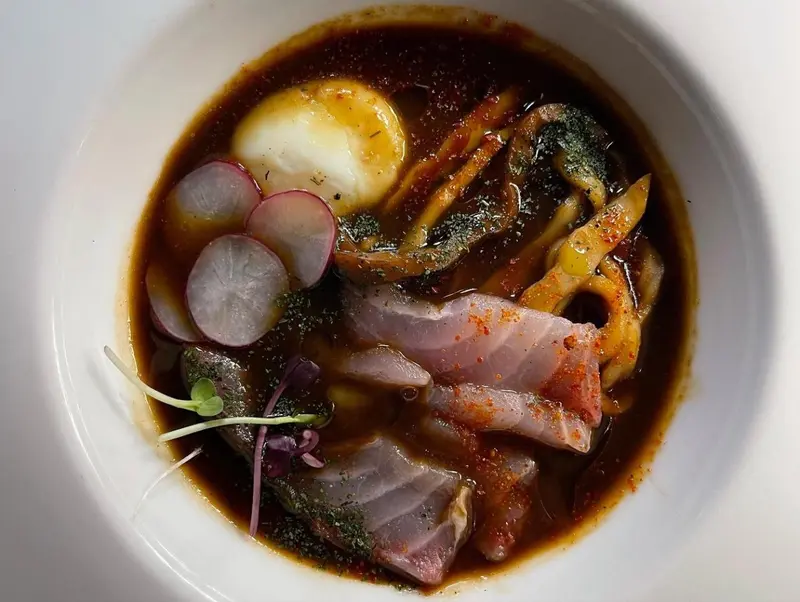 Un plat de nouilles et de poisson servi dans un bol blanc.