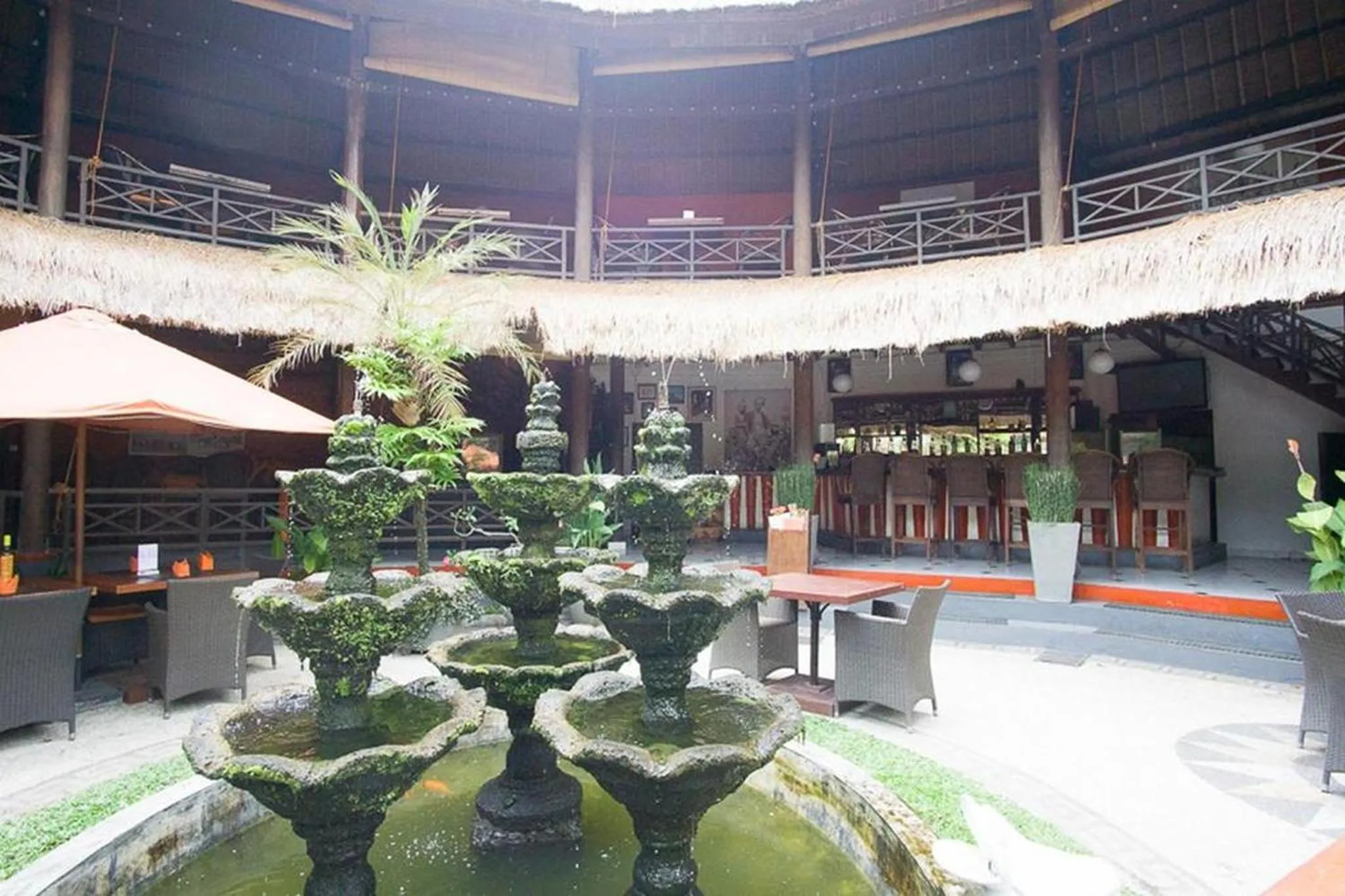 Une cour intérieure avec des fontaines, des plantes et des tables.