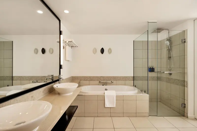 Une salle de bain lumineuse avec baignoire et douche à l'italienne.