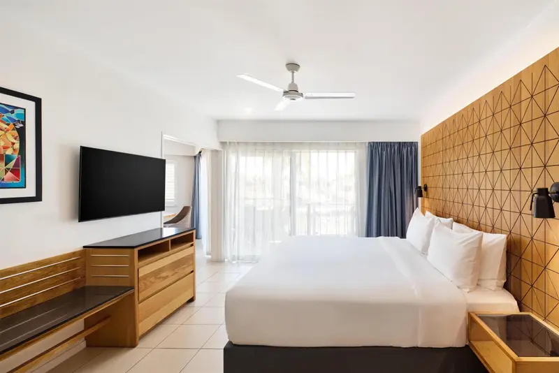 Une chambre lumineuse avec un grand lit et un accès à une terrasse.