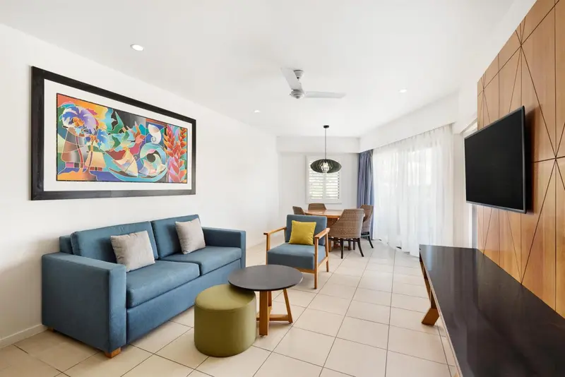 Un salon moderne avec canapé bleu et table basse.