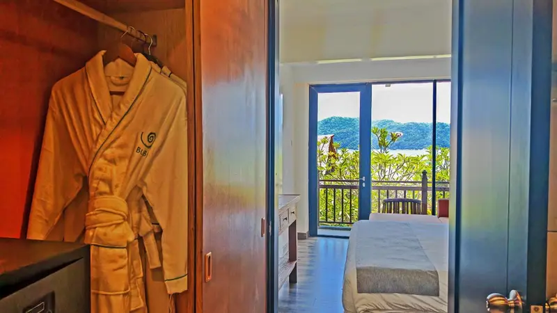 Une chambre lumineuse s'ouvre sur une vue verdoyante.