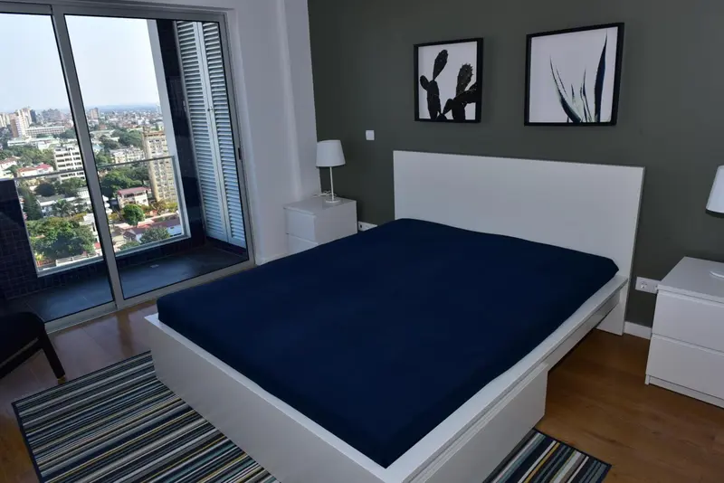 Une chambre moderne avec un grand lit et une vue sur la ville.