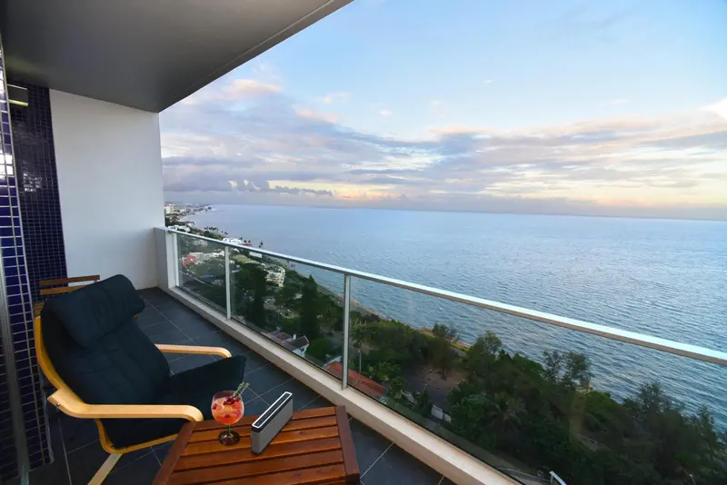 Une terrasse avec une vue sur la mer au coucher du soleil.