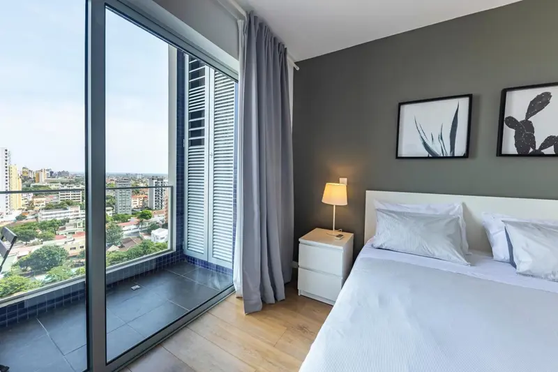 Chambre moderne avec un grand lit et une vue sur la ville.