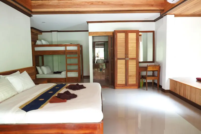Une chambre lumineuse avec un lit superposé et un lit double.