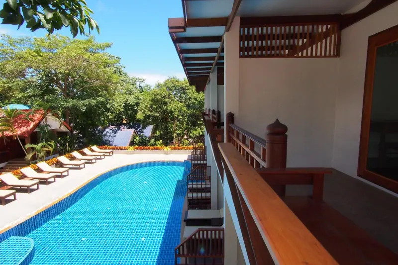 Terrasse avec vue sur une piscine et une végétation luxuriante.