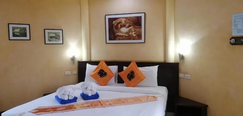 Une chambre avec un grand lit décoré de coussins et d'animaux en serviette.