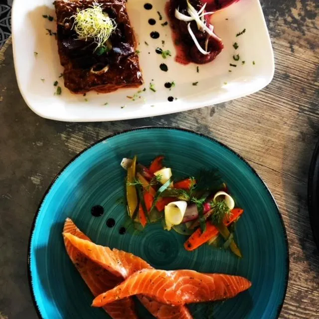 Assiettes de plats raffinés avec des éléments colorés et une présentation soignée.