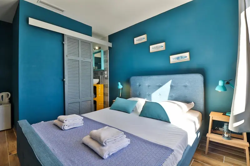 Une chambre lumineuse avec un grand lit et une décoration marine.