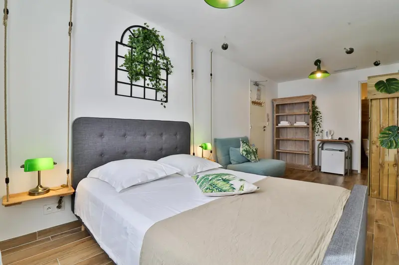 Une chambre lumineuse avec un grand lit et une décoration tropicale.
