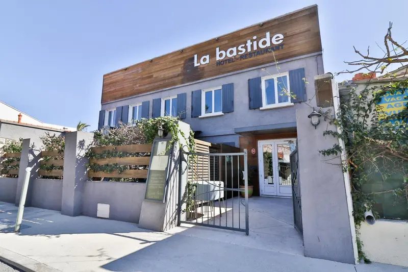 Façade d'un bâtiment avec une entrée et un jardin soigné.