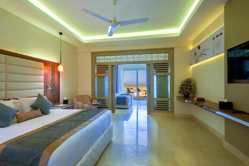 Une chambre lumineuse avec un grand lit et un accès à une terrasse.