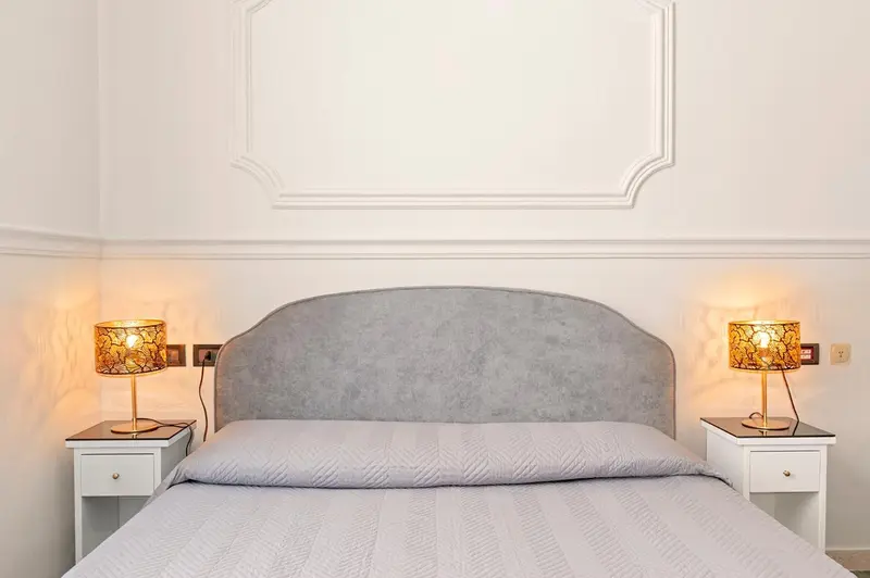 Une chambre lumineuse avec un grand lit et des lampes de chevet.