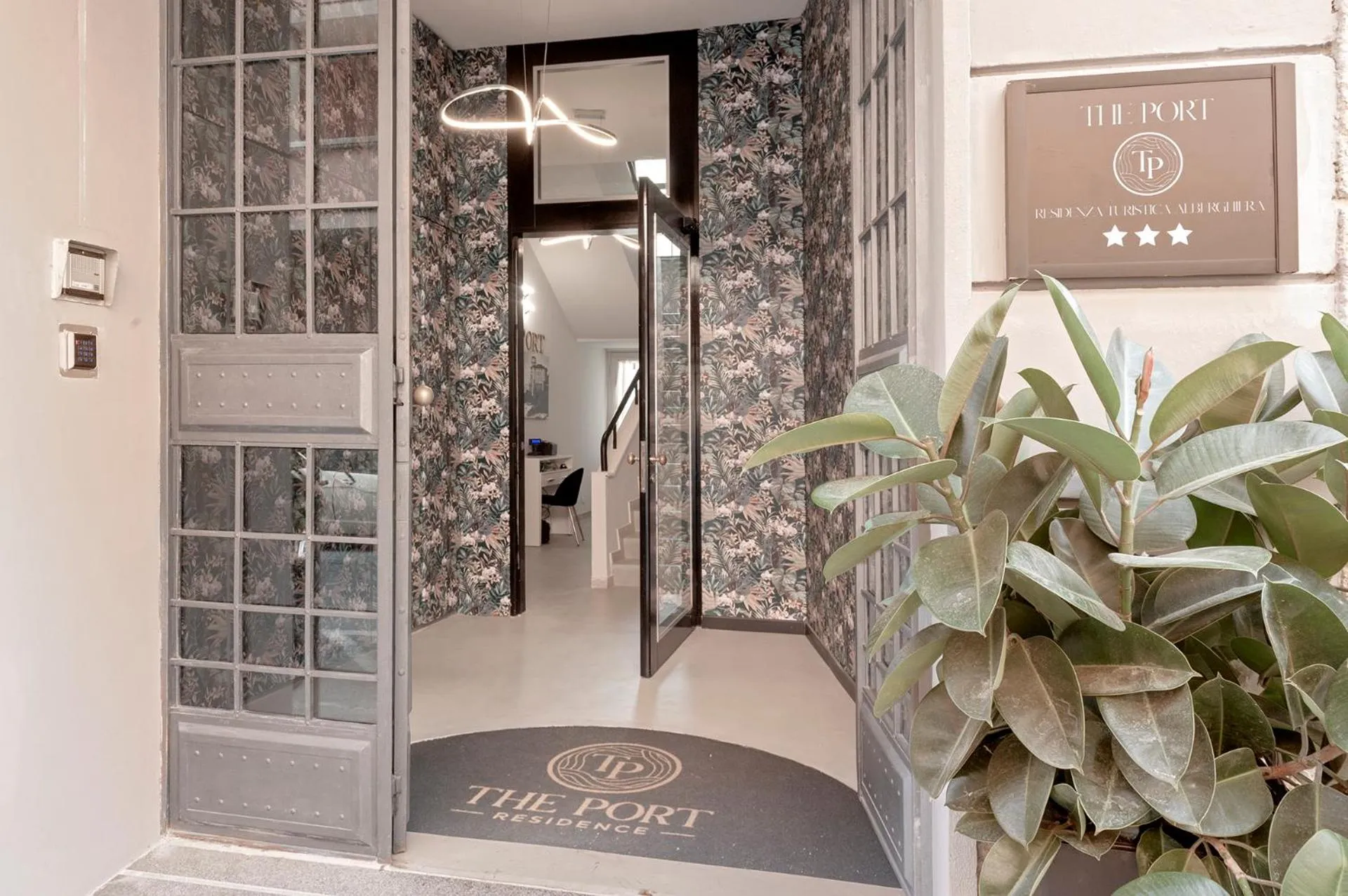 Entree d'un residence avec une porte ouverte sur un interieur clair.
