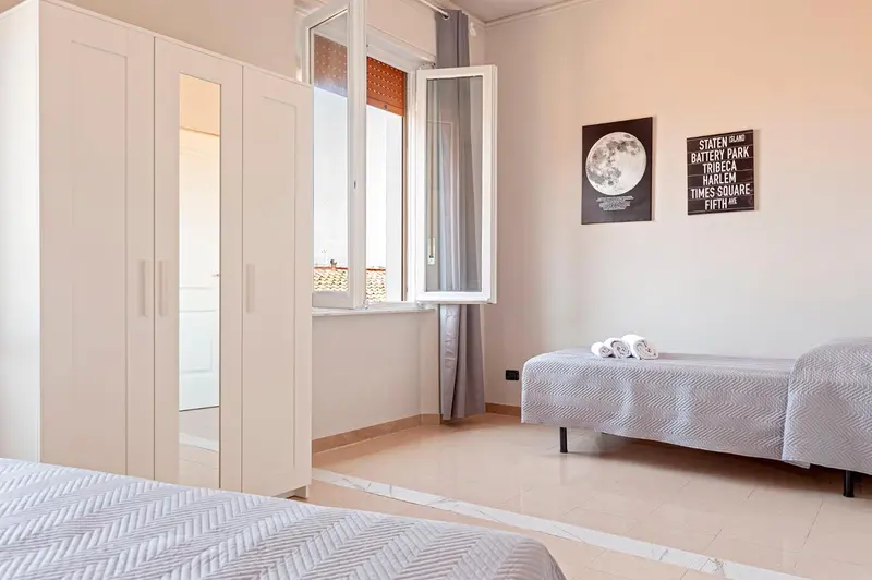 Une chambre lumineuse avec un lit et un canapé près d'une fenêtre.