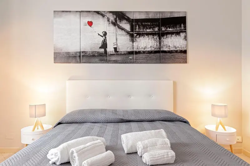Une chambre avec un grand lit et une décoration murale.