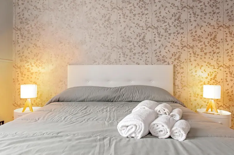 Un lit double avec des oreillers et des serviettes pliées sur le couvre-lit.