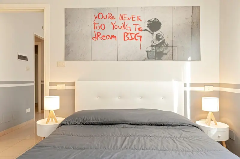 Une chambre moderne avec un grand lit et une décoration murale colorée.