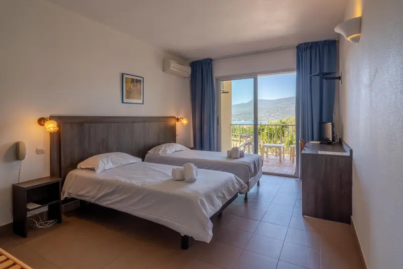 Une chambre lumineuse avec un grand lit et un accès à un balcon.