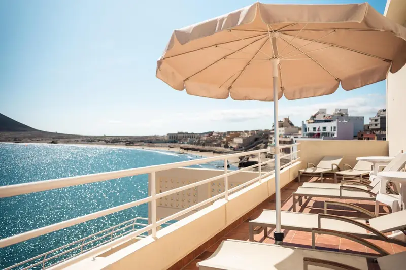 Terrasse avec transats donnant sur la mer et le littoral.