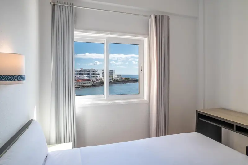 Une chambre lumineuse avec vue sur la mer et la ville.
