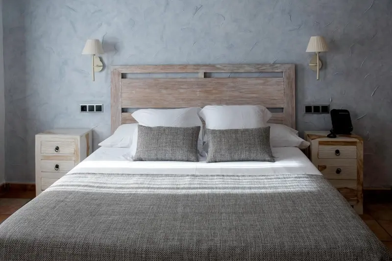Un lit double avec des oreillers et une couverture est dans une chambre.