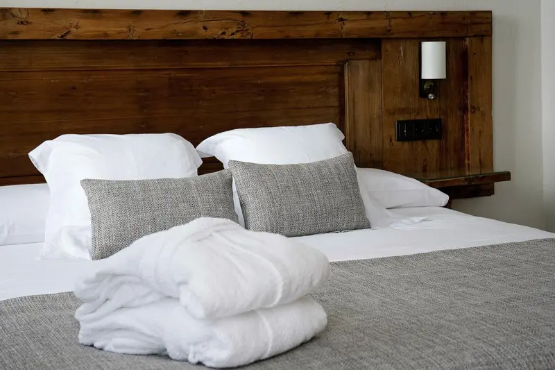 Un lit confortable avec des oreillers et des couvertures blanches est prêt pour le repos.