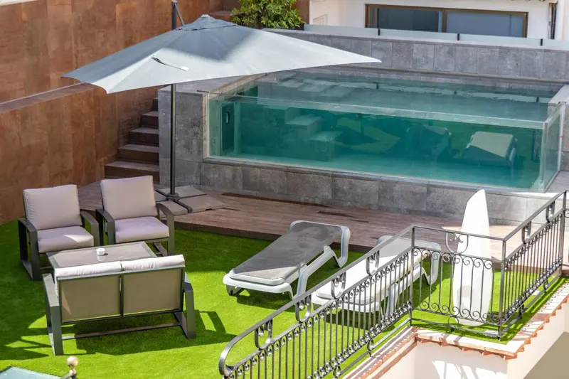 Espace extérieur aménagé avec piscine, chaises longues et mobilier de jardin.